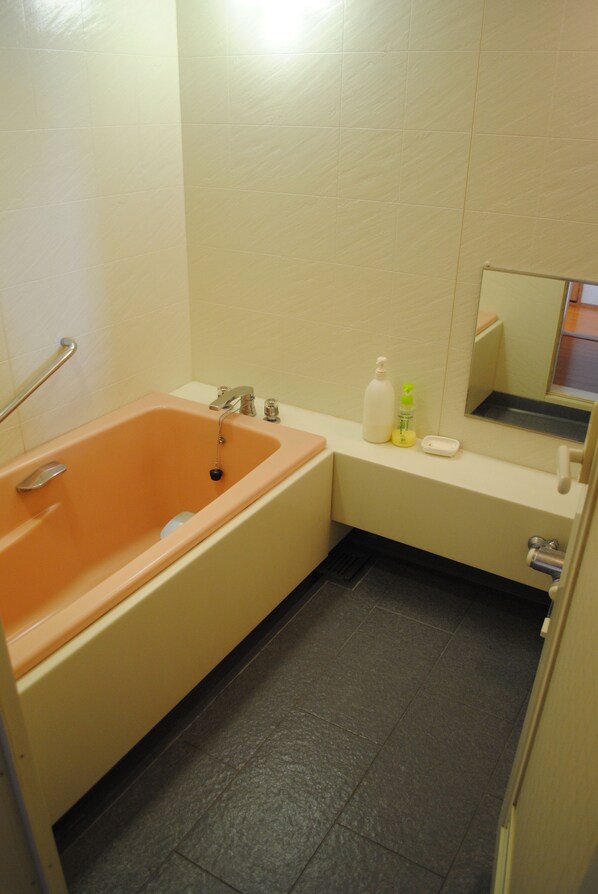Une salle de bain avec une baignoire, un lavabo et un miroir.