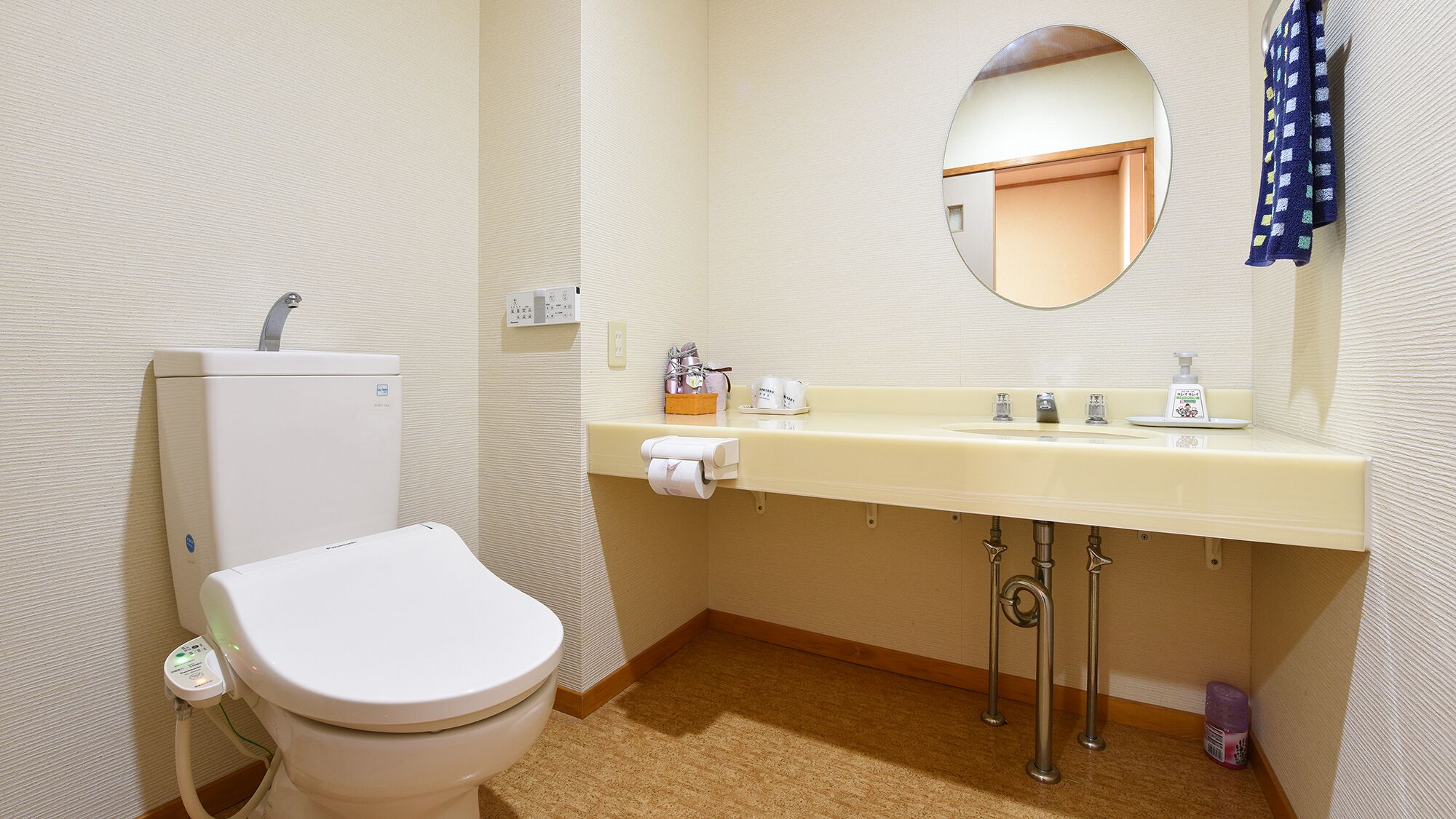 A small, clean bathroom with a toilet, sink, and mirror.
