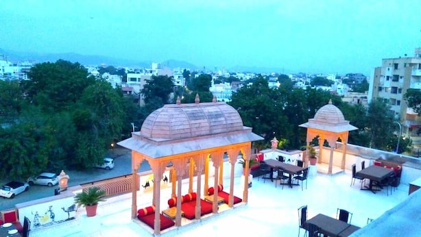 A rooftop terrace with a gazebo, seating area, and a view of the cityscape. - Hotel Castle Inn (Udaipur)