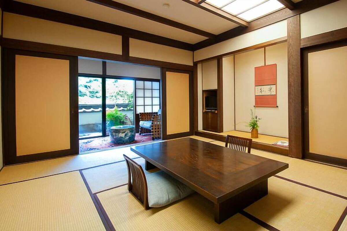 Une pièce de style japonais traditionnel, avec un sol recouvert de tatamis, une basse table en bois et des portes coulissantes.
