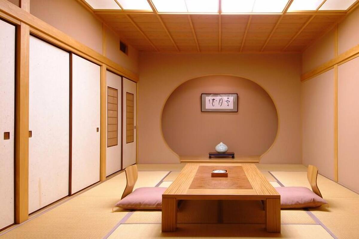 Une pièce de style japonais traditionnel, avec un sol recouvert de tatamis, une basse table en bois et des portes coulissantes.