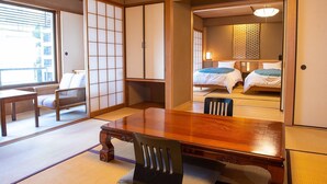 Une pièce de style japonais traditionnel, avec un sol recouvert de tatamis, une table en bois et un futon servant de lit.