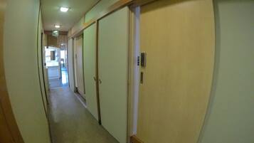 A narrow hallway with doors on both sides, leading to rooms.