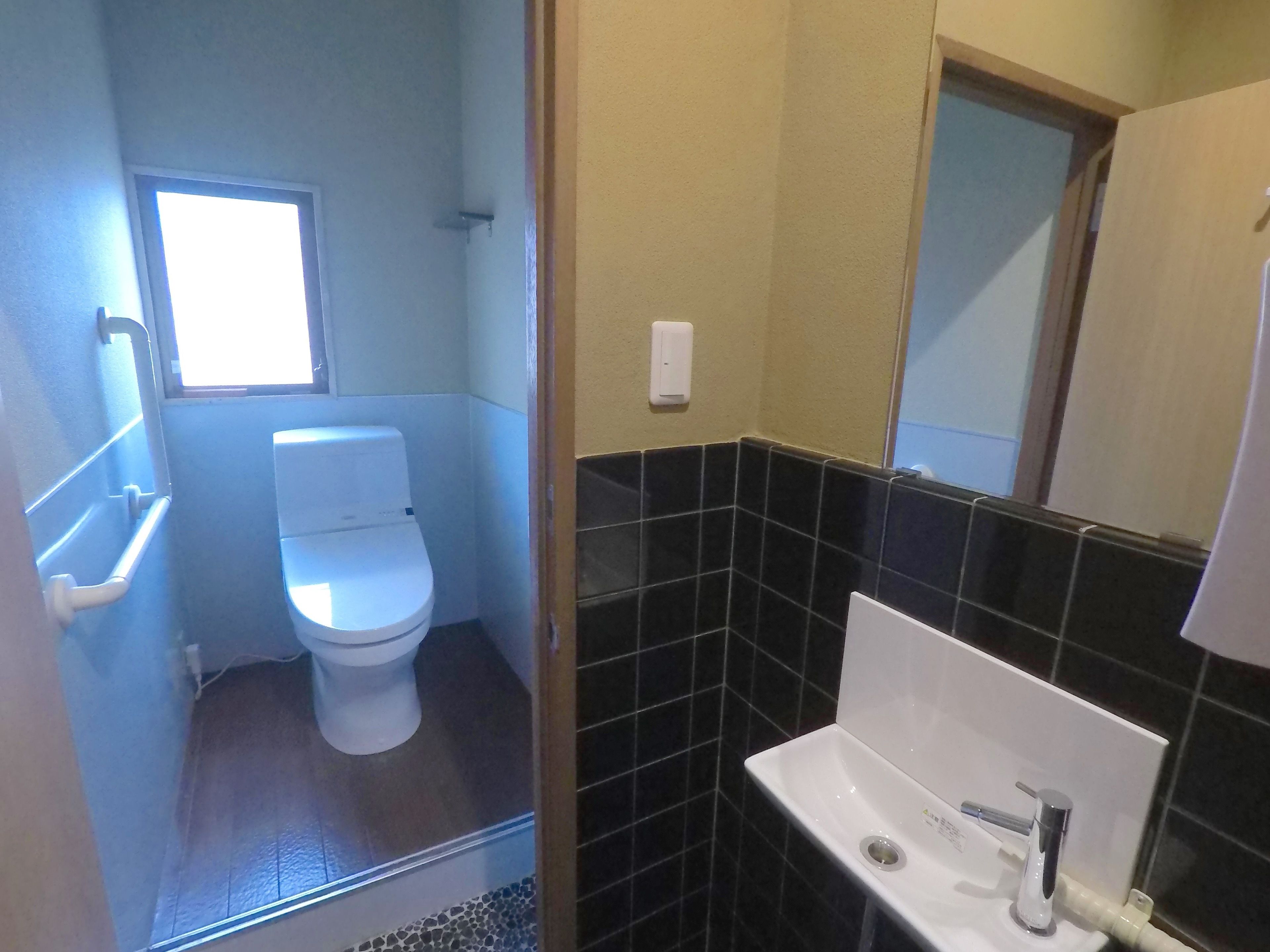 Ein kleines Badezimmer mit Toilette, Waschbecken und Fenster.