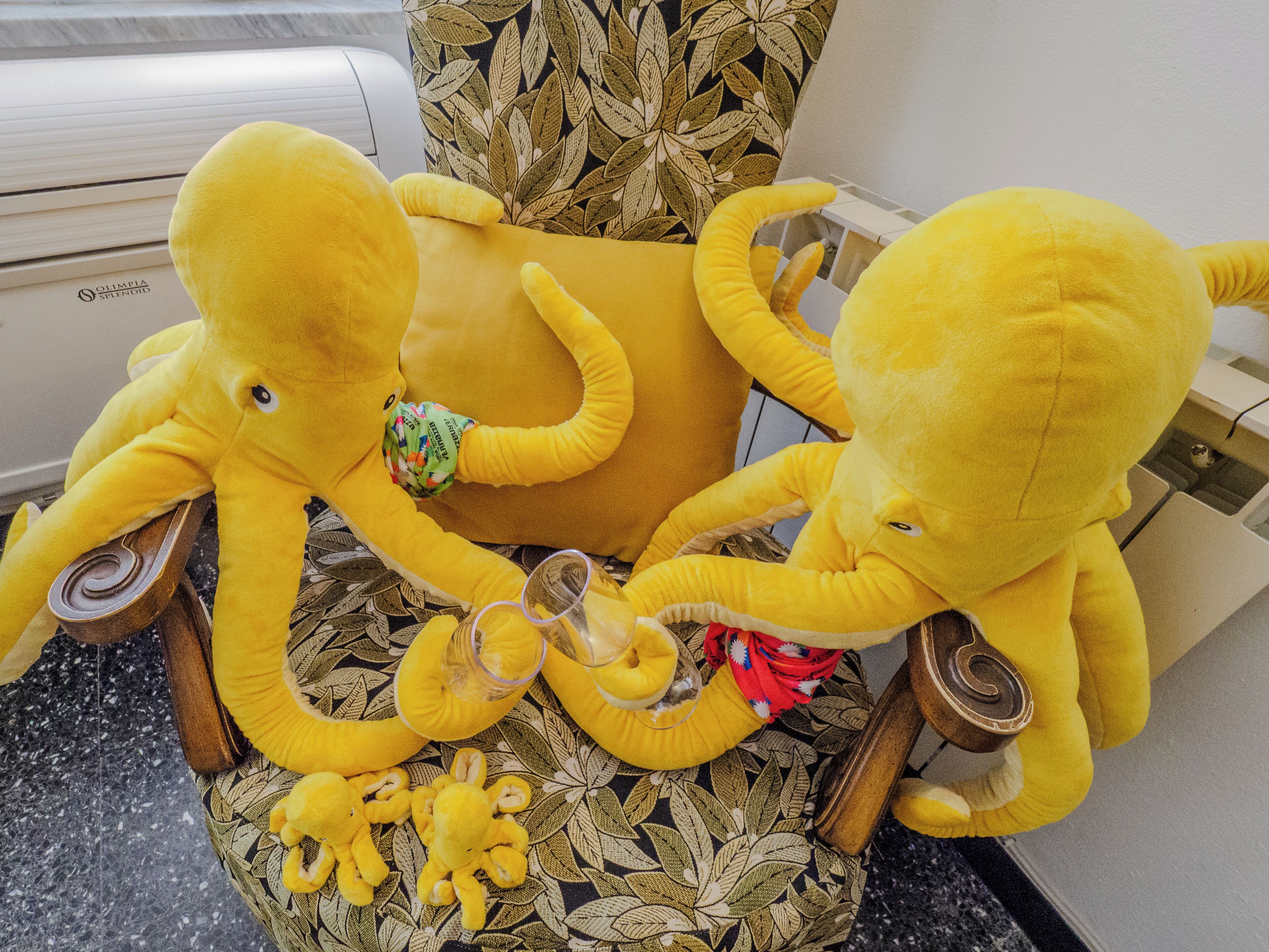 Um elefante de pelúcia sobre uma cadeira estampada.