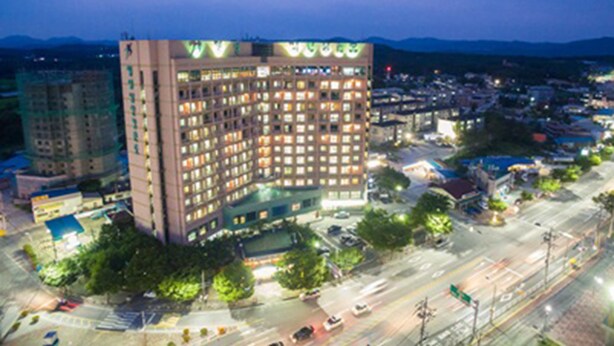 Un hotel de varios pisos con un patio central y vistas del área urbana circundante.
