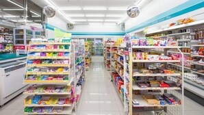 Un pasillo de supermercado con estantes llenos de diversos productos, áreas de refrigeración y un ambiente limpio y bien iluminado.