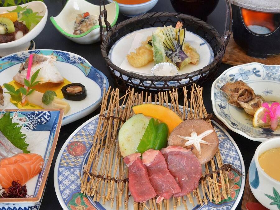 A variety of Japanese dishes on a table, including sushi, sashimi, and tempura.