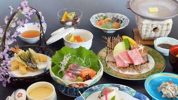 A variety of Japanese dishes including sushi, sashimi, and tempura, served on traditional ceramic plates and bowls.