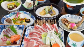 Variedad de platillos y alimentos en una mesa, incluyendo sashimi, tempura y otras preparaciones de la cocina japonesa.