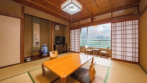 Um quarto japonês tradicional com tatames, uma mesa de madeira e biombos shoji.