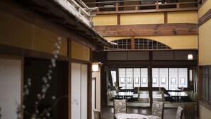 Un intérieur de style japonais traditionnel, avec un sol recouvert de tatamis, des poutres en bois et des panneaux coulissants en papier.