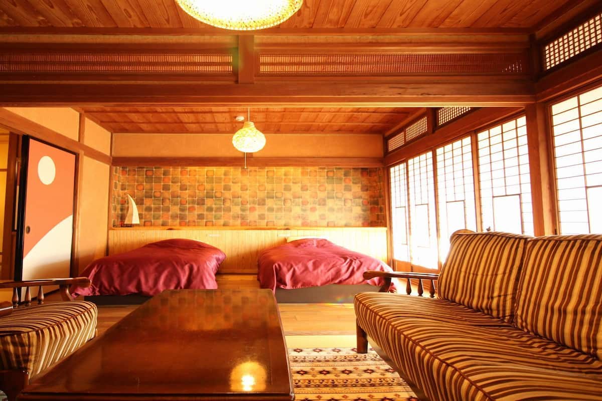 Ein traditioneller japanischer Raum mit Tatami-Bodenbelag, einer niedrigen Holzdecke und Schiebetüren.
