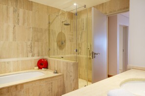 A modern bathroom with two sinks, a glass shower enclosure, and a mirror.