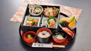 A traditional Japanese bento box with various food items including sushi, sashimi, rice, and pickled vegetables. - Hotel Matsuo (Hamada)