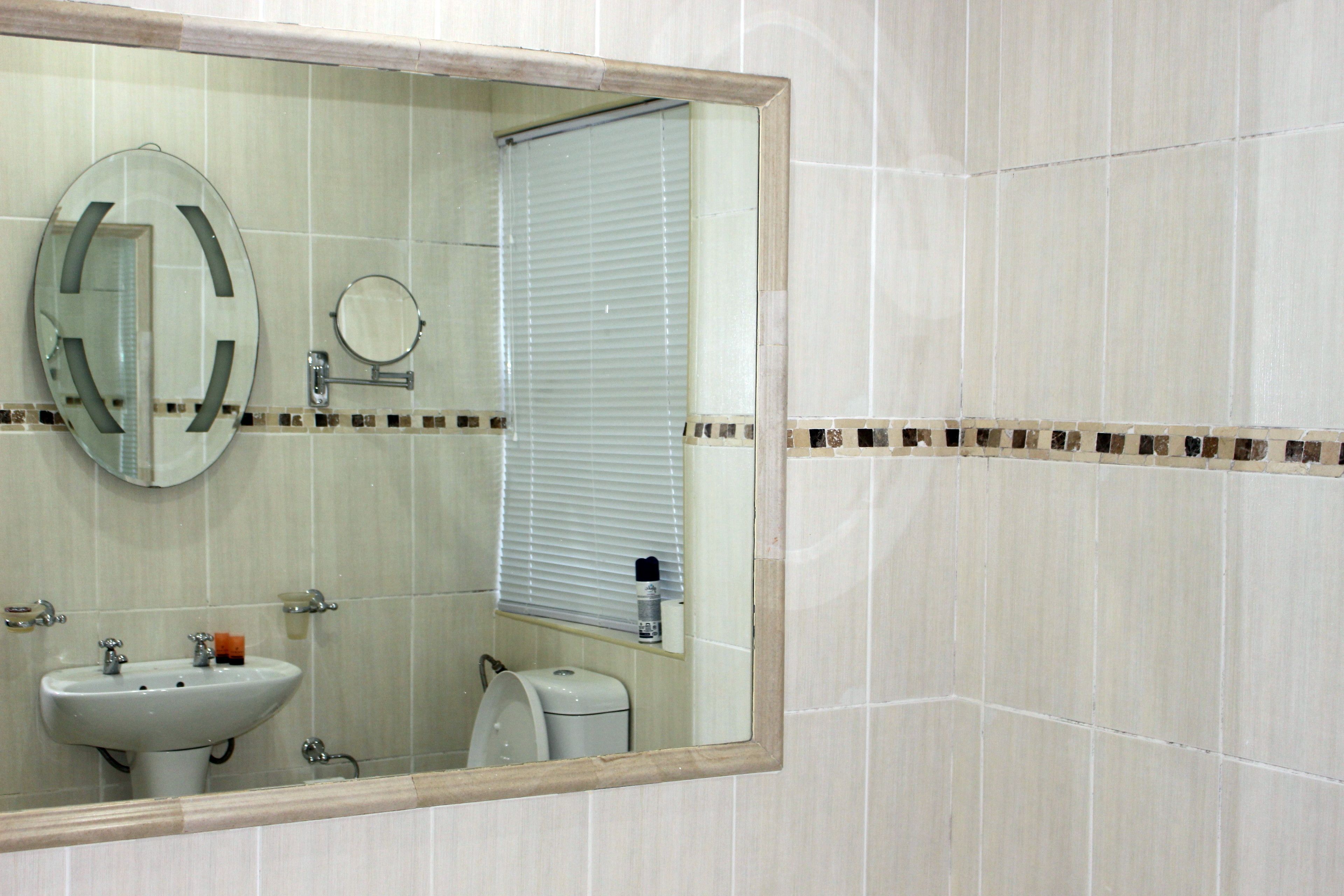 A bathroom with a sink, mirror, and toilet.