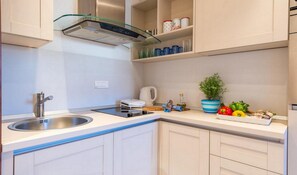 Apartamento premium, 1 quarto, sacada | Cozinha privada | Geladeira, micro-ondas, fogão, cooktop