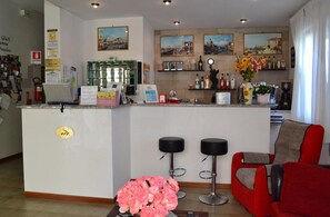A hotel lobby with a reception desk, bar area, and seating. - Hotel Villa Roberta (Jesolo)