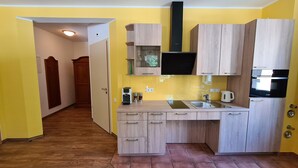 Una cocina compacta con armarios de madera, horno empotrado y cafetera.