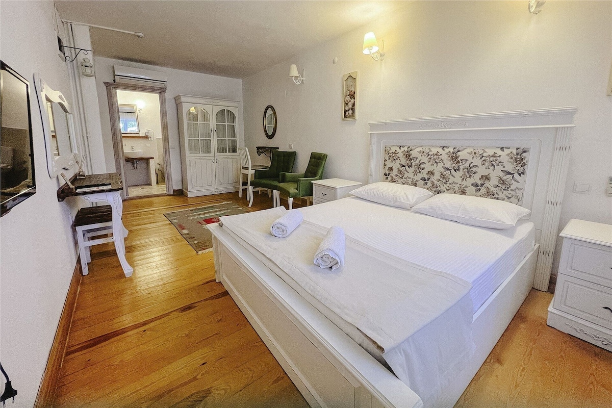 Une chambre d’hôtel comprenant un lit, un bureau, une chaise, une armoire et une salle de bain.