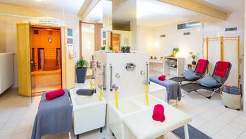 Relax in a serene spa room with a sauna, reception desk, and comfortable seating area.