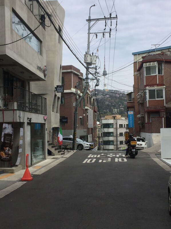 A street view with buildings, a scooter, and a car.