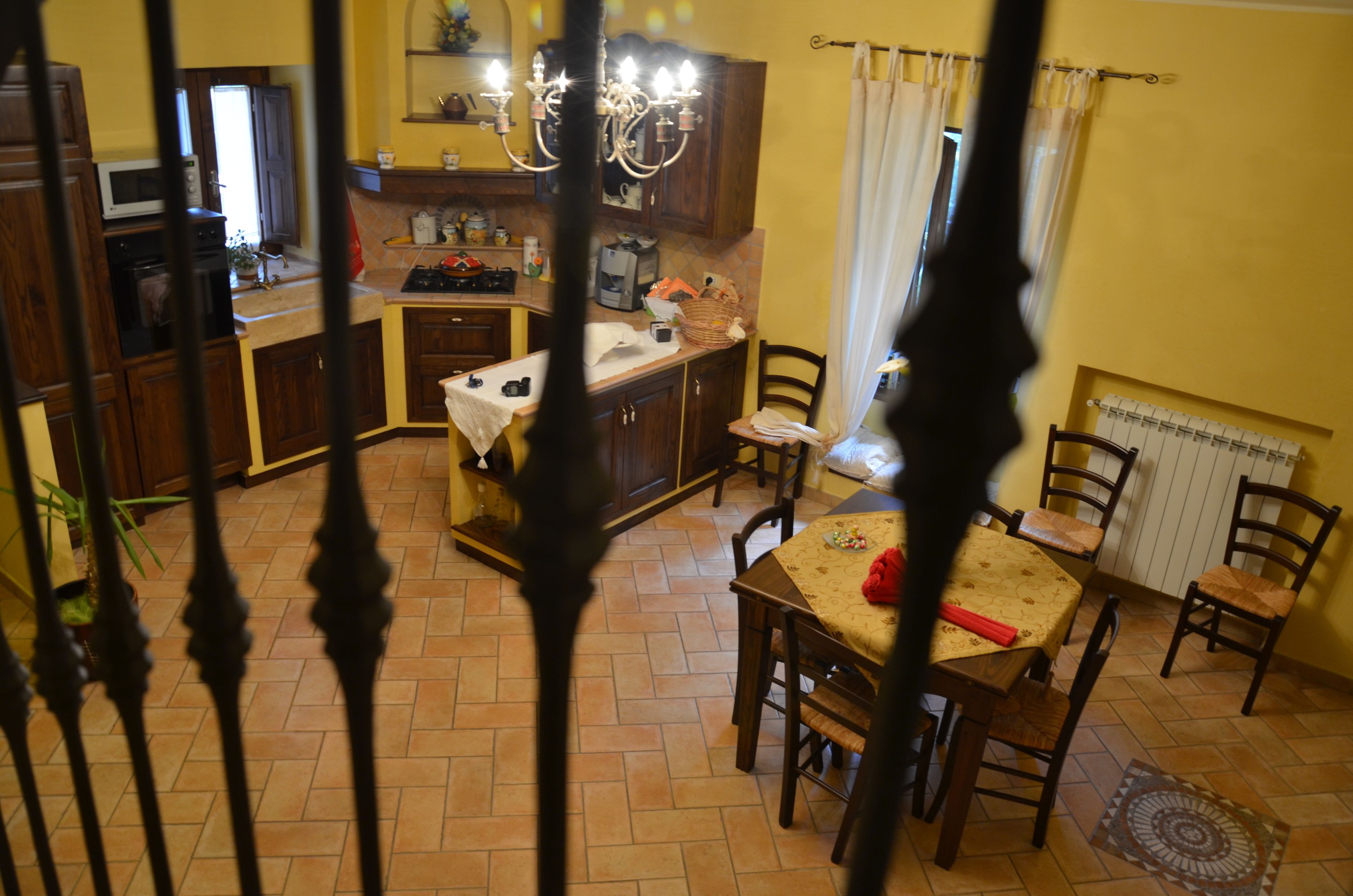 A kitchen with wooden cabinets, a dining table with chairs, and a chandelier.