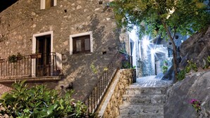 Una escalera de piedra que lleva a un edificio con una ventana pequeña y una puerta.