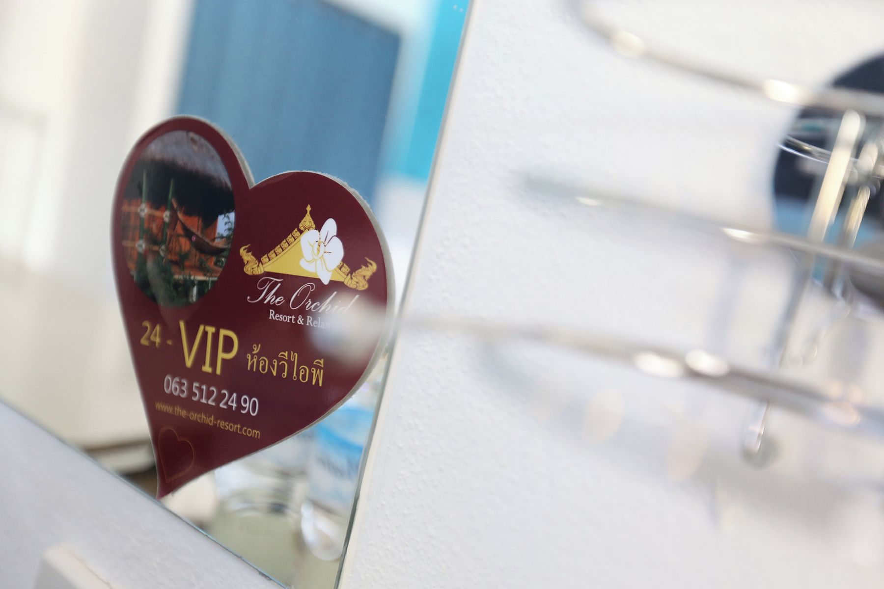 A heart-shaped sign with 'The Orchid Resort & Spa' and a phone number.
