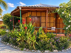 A traditional wooden house with a thatched roof, a wooden porch, and a bench. - The Orchid Resort & Relax (Kantharawichai)