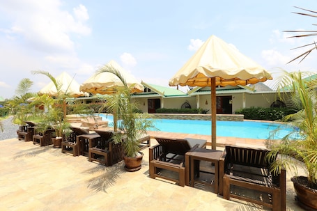 Una piscina al aire libre, sillones reclinables de piscina