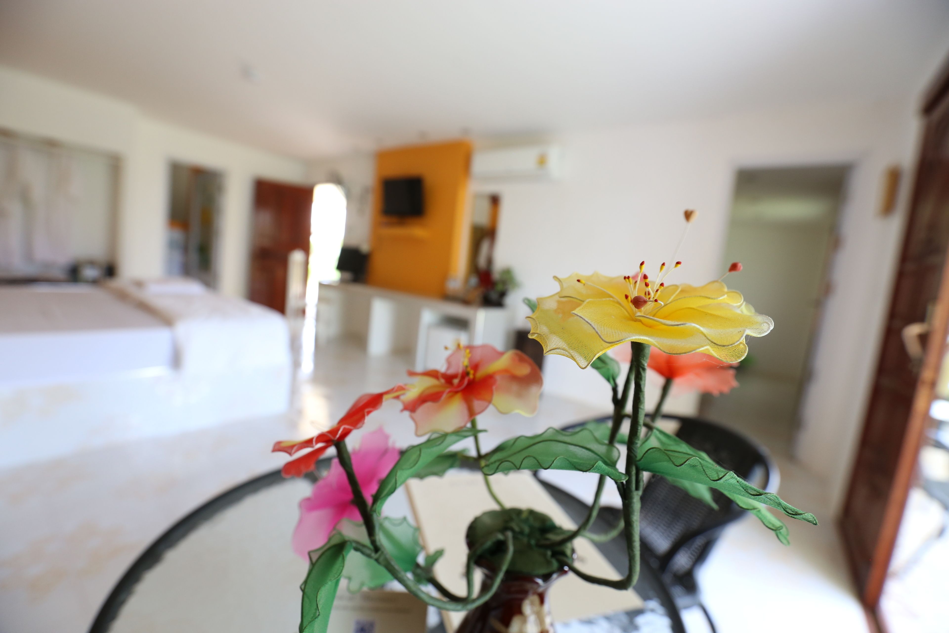 A hotel room with a bed, a dining area, and a living space.