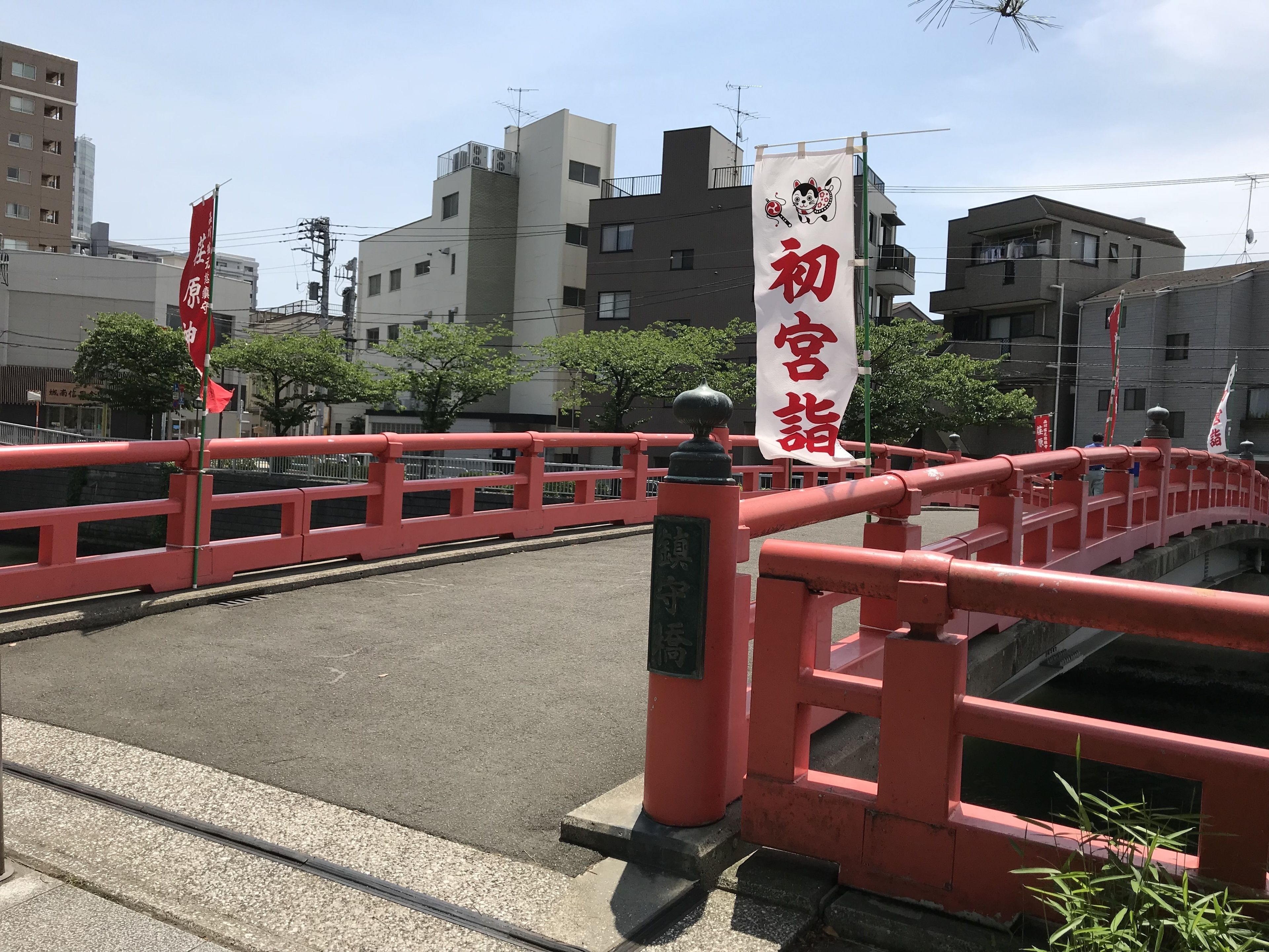 A red bridge with a banner displaying Japanese characters.