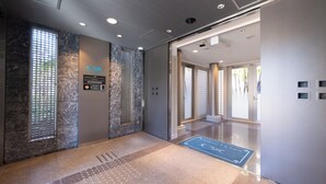 A modern elevator interior with marble walls, a digital display, and a clear floor plan. - Keikyu EX Inn Shinagawa Shimbamba (Tokyo)