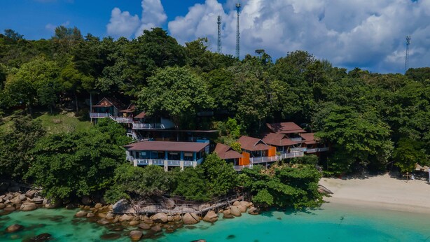 A coastal resort with multiple buildings surrounded by lush greenery and a clear turquoise beach. - Chareena Hill Resort - Pattaya Beach Koh Lipe (Koh Lipe)