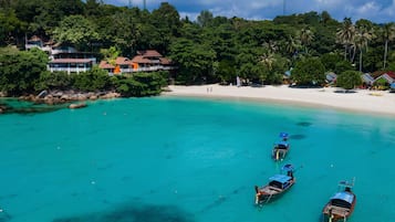 On the beach, white sand, sun loungers, beach towels