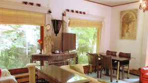 Un salón comedor amplio con un gran ventanal y televisor.