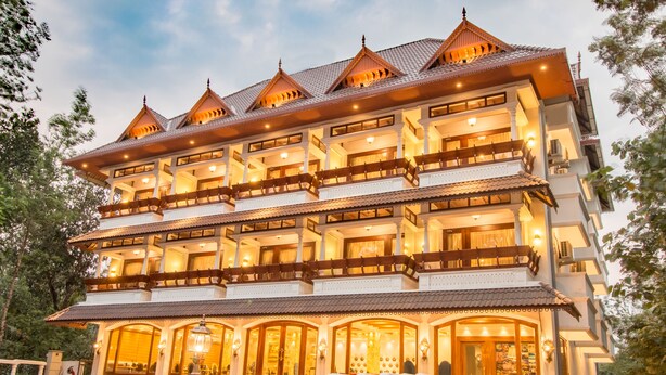 Un hotel de varios pisos con un estilo arquitectónico tradicional, que cuenta con balcones y una entrada bien iluminada.