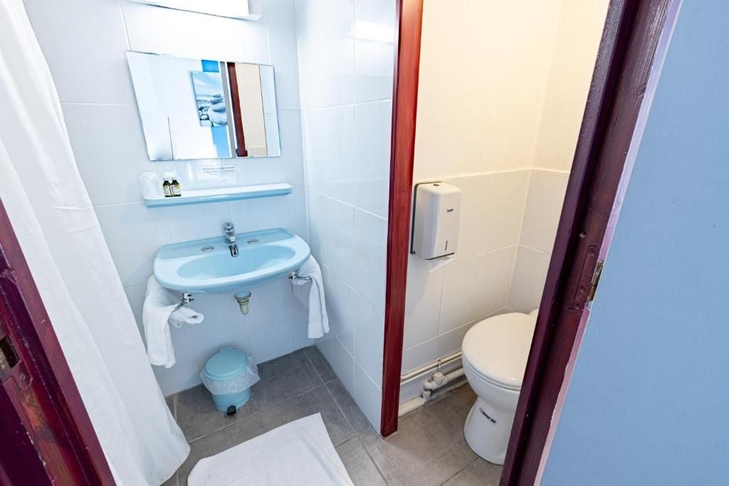 A bathroom with a sink, mirror, and toilet.