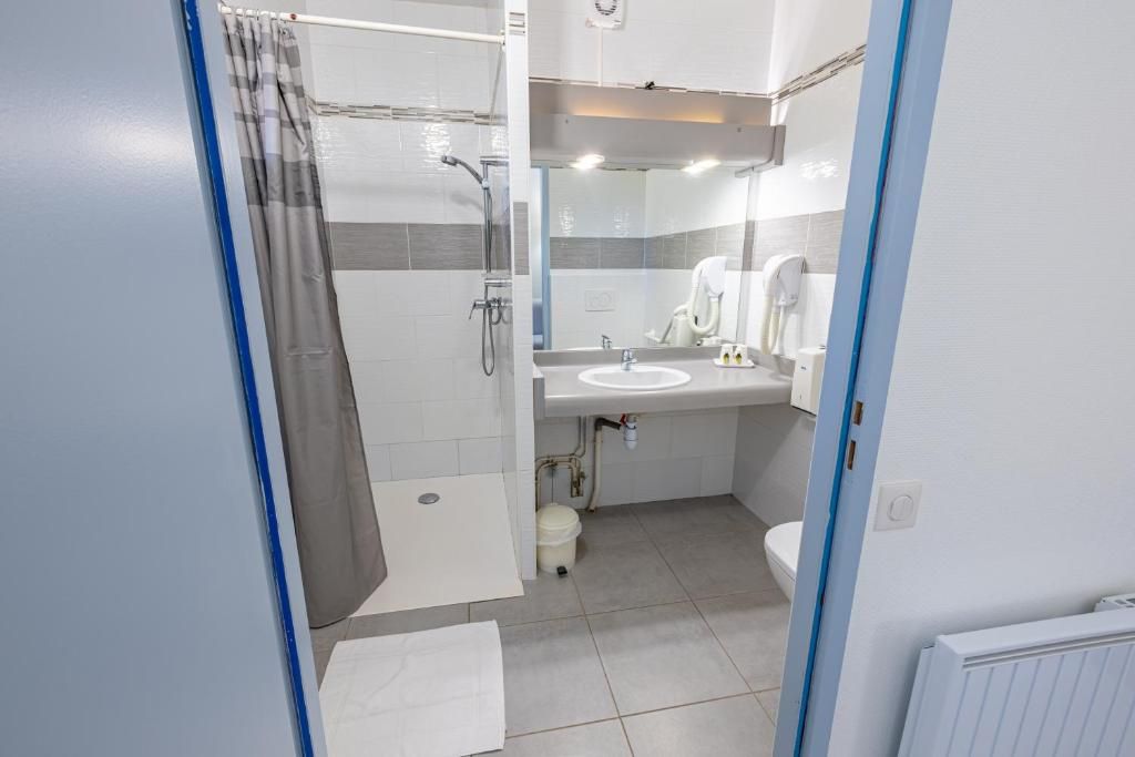 A modern bathroom with a shower, toilet, and sink.