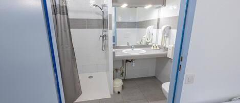 A modern bathroom with a shower, toilet, and sink.