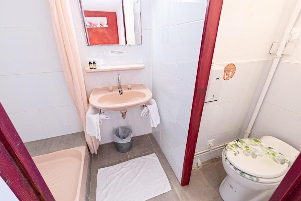 Ein Badezimmer mit Waschbecken, Spiegel und Toilette.