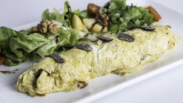A plate with a rolled omelette, a side salad, and walnuts.