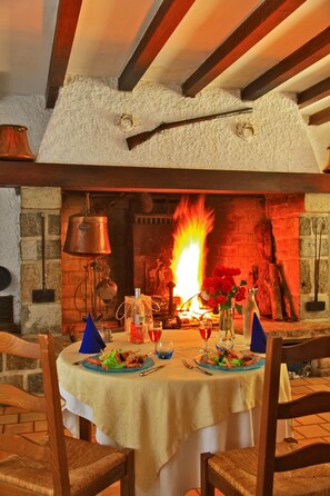 A dining table set for four with a fireplace in the background. - Le Clos Grand (Pradines)