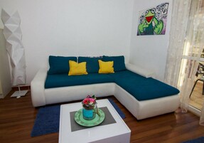 Appartamento, 1 camera da letto, vista giardino | Area soggiorno | TV a schermo piatto