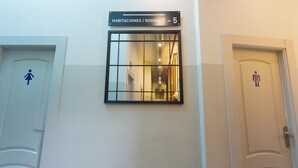 A hotel room with a sign indicating rooms 1-5. - Málaga Stop Hostel (Málaga)
