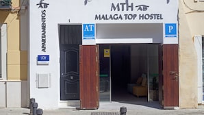 A hostel named 'MTH AB MALAGA TOP HOSTEL' with a sign indicating 'AT TRINIDAD' and 'P CIUDAD' parking. - Málaga Stop Hostel (Málaga)