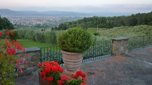 A view of a city from a high vantage point, with a stone railing and potted plants in the foreground. - Tenuta le Viiste (Scandicci)