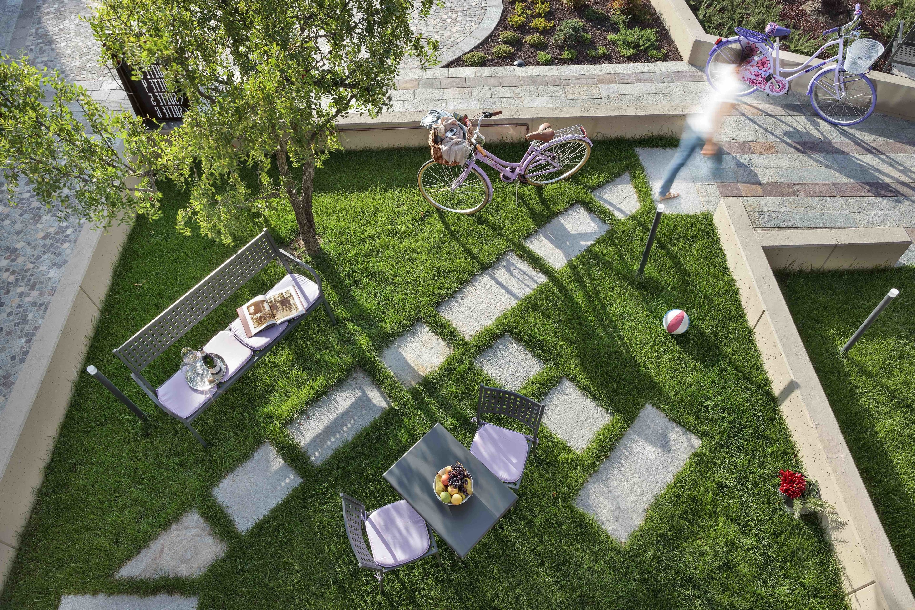 Un patio con una mesa, sillas, una bicicleta y un jardín.
