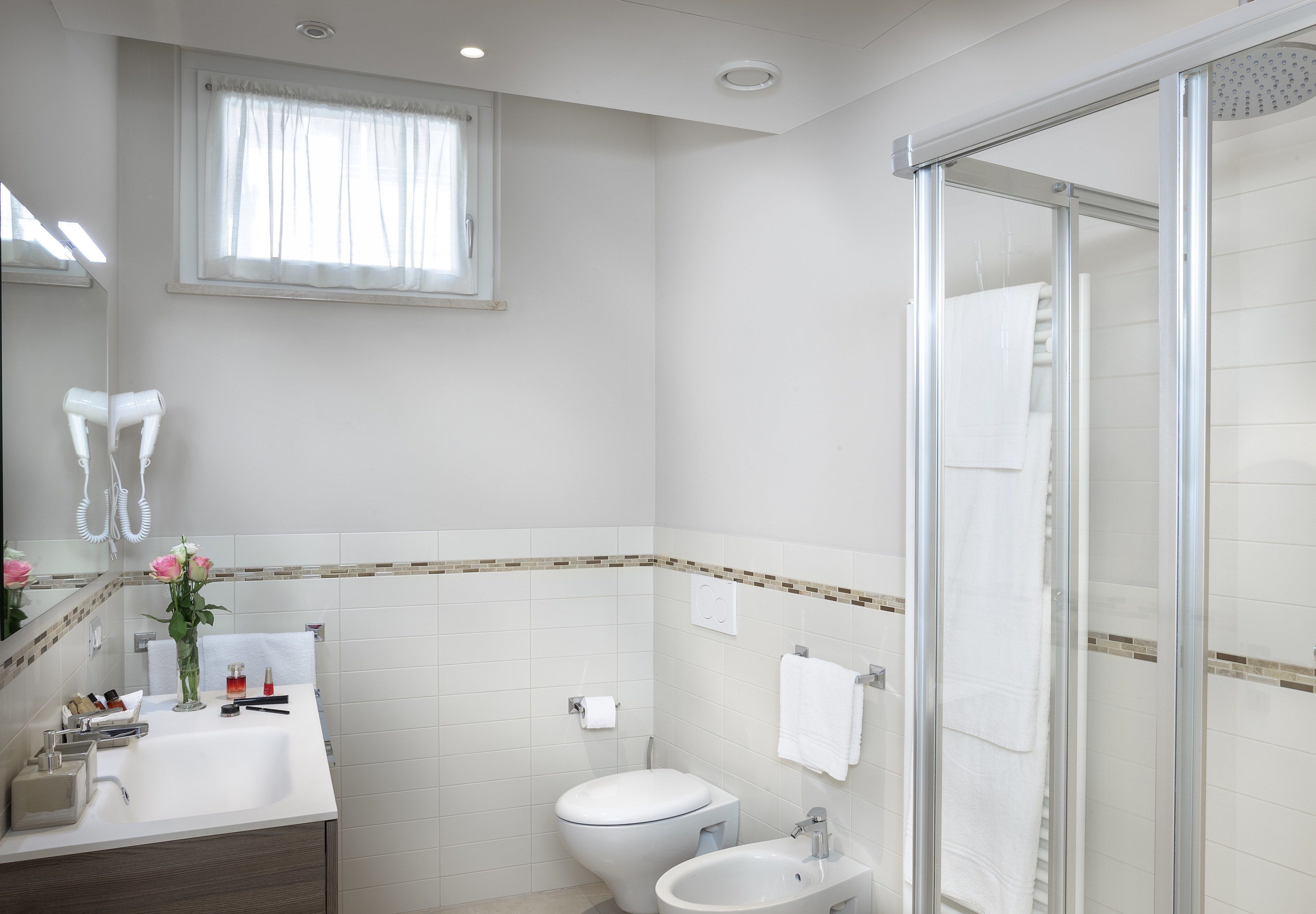 Ein modernes Badezimmer mit Dusche, Toilette, Waschbecken und Spiegel.
